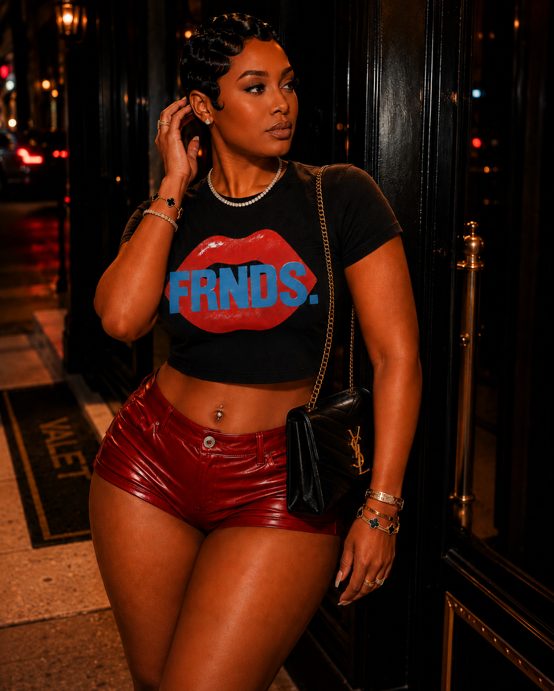 Model wearing the black FRNDS lips crop top with red leather shorts at night