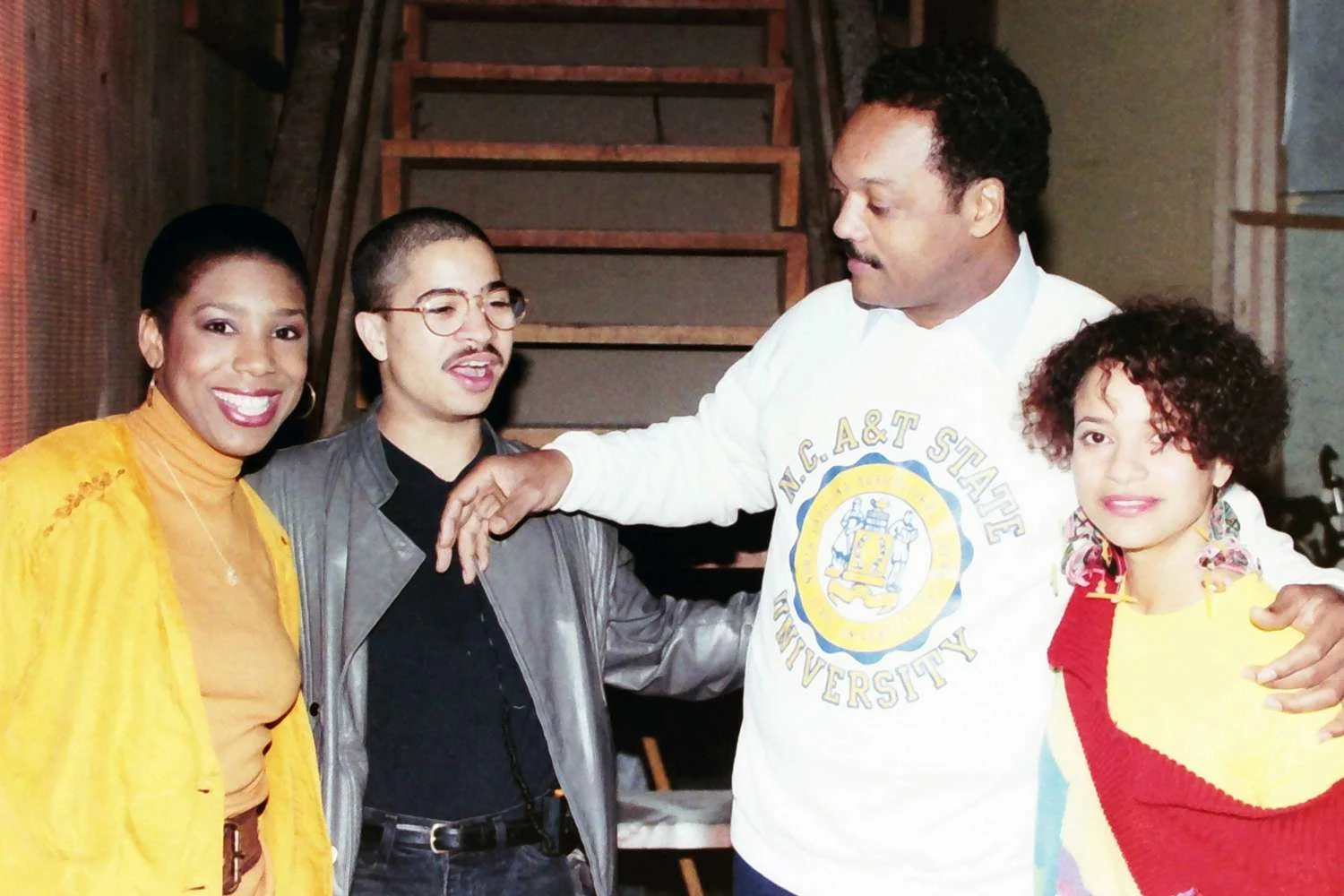 Archival photograph of Debbie Allen on set with A Different World cast members and Jesse Jackson