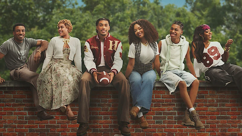The new A Different World cast seated together on a brick wall